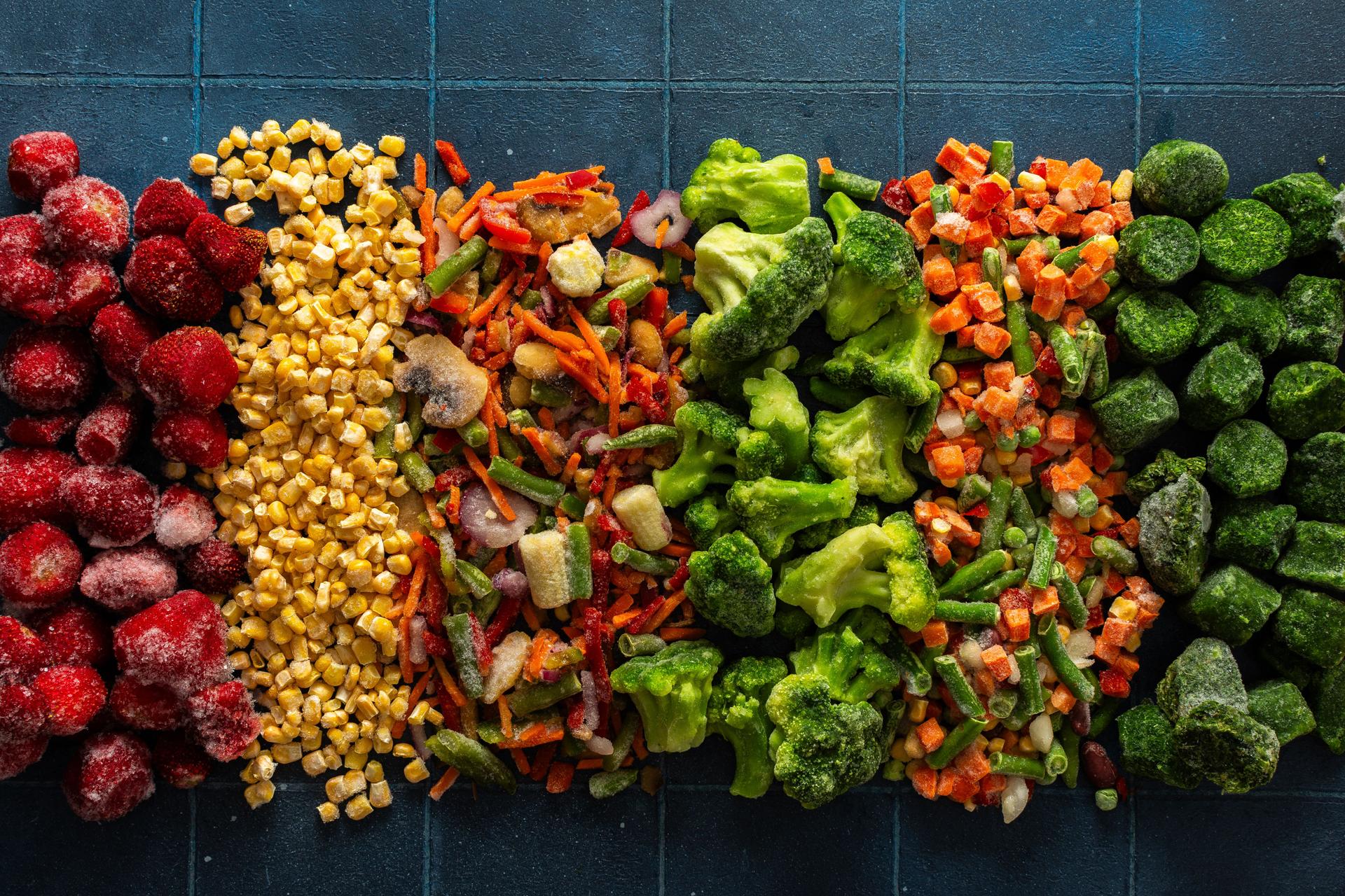 A vivid display of frozen fruits and vegetables in a colorful arrangement, illustrating the process of preserving healthy, seasonal produce for winter, promoting a healthy diet